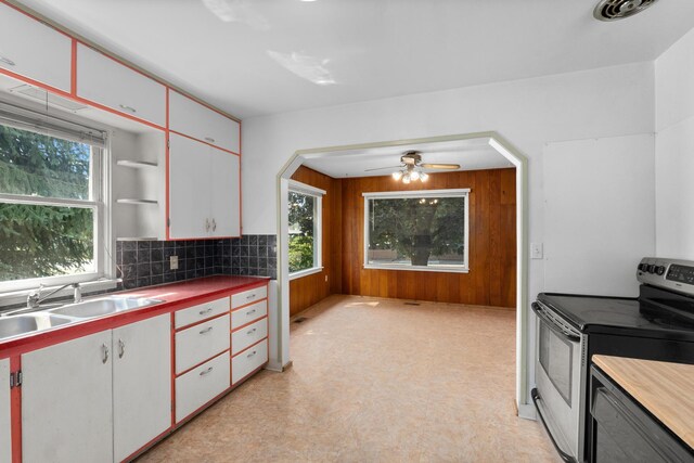 kitchen featuring sink, white cabinetry, a healthy amount of sunlight, and electric stove