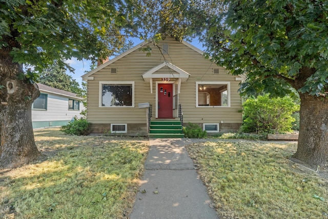 bungalow-style home with a front yard