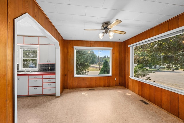 unfurnished sunroom featuring a healthy amount of sunlight and ceiling fan