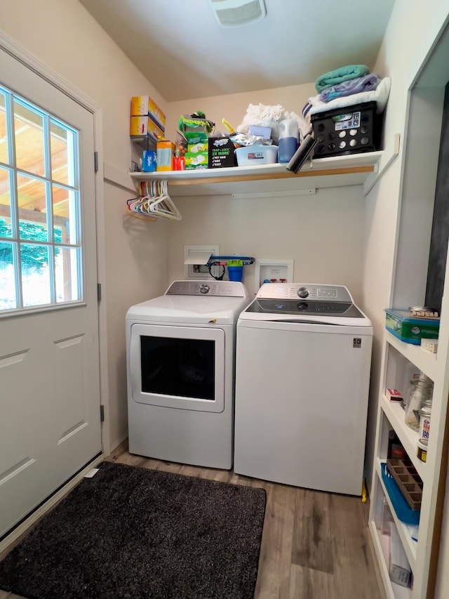 laundry area featuring light wood-type flooring, visible vents, separate washer and dryer, and laundry area
