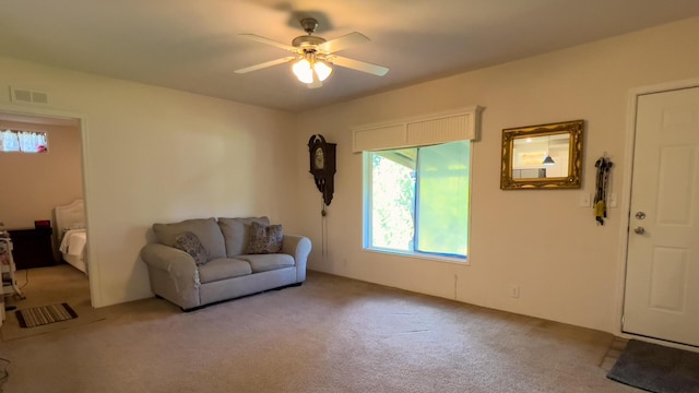 carpeted living area featuring visible vents and ceiling fan