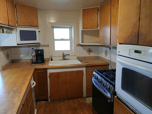 4224 Grouse Creek Rd, Loon Lake, WA 99148 - kitchen featuring white appliances, decorative backsplash, brown cabinets, and dark wood-type flooring