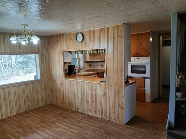 4224 Grouse Creek Rd Unit C, Loon Lake, WA 99148 - interior space with white oven, an inviting chandelier, wood finished floors, and a sink