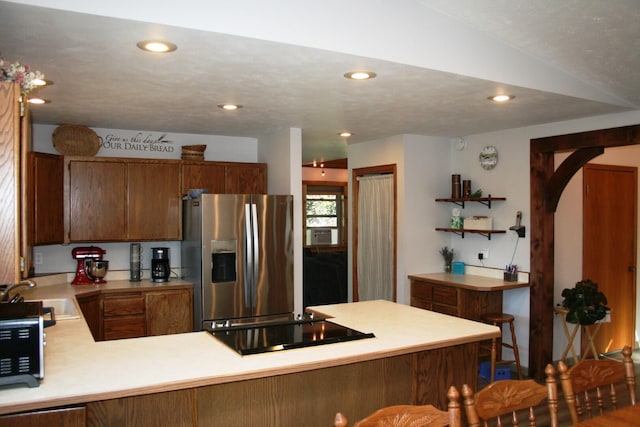 4738 Price Rd, Clayton, WA 99110 - kitchen featuring stainless steel fridge, a sink, black electric cooktop, light countertops, and a peninsula