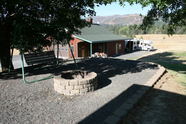 4738 Price Rd, Clayton, WA 99110 - view of home's exterior with an outdoor fire pit, a mountain view, a chimney, and a shingled roof