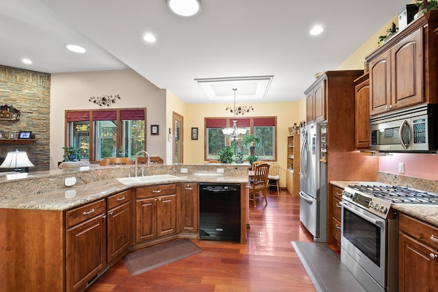 420 Palmer Ln, Chewelah, WA 99109 - kitchen with light stone countertops, appliances with stainless steel finishes, an inviting chandelier, a sink, and dark wood-style floors