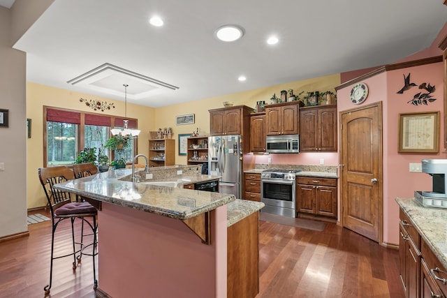 420 Palmer Ln, Chewelah, WA 99109 - kitchen with a kitchen breakfast bar, dark wood-style flooring, light stone countertops, a sink, and stainless steel appliances