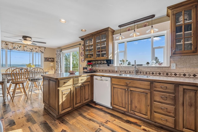 kitchen with a sink, tasteful backsplash, ceiling fan, and dishwasher
