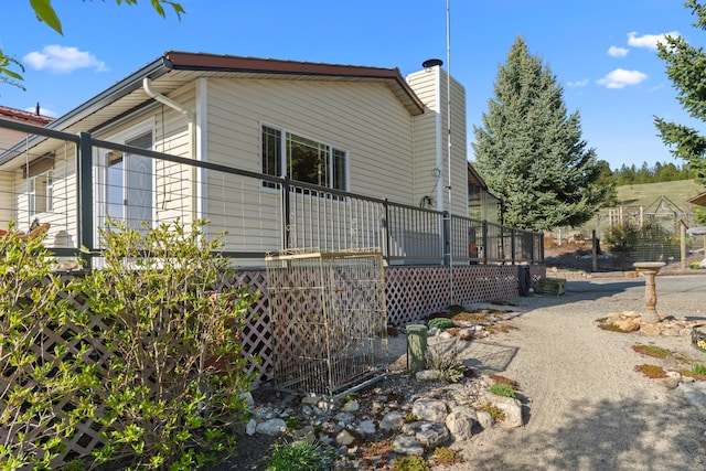 view of home's exterior with a chimney and a deck