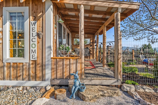 exterior space featuring covered porch and fence
