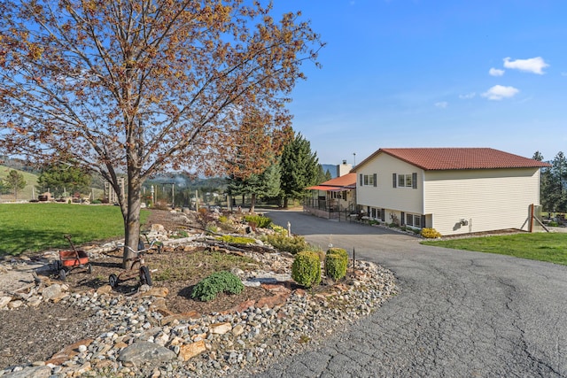 view of property exterior featuring a lawn and a tiled roof