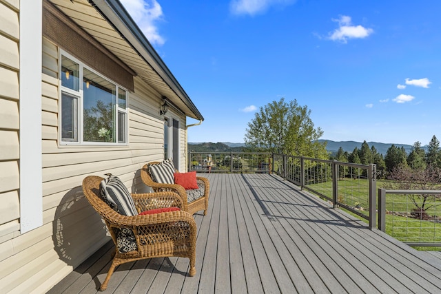 wooden deck featuring a lawn and a mountain view