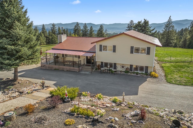 tri-level home featuring a deck with mountain view and a chimney