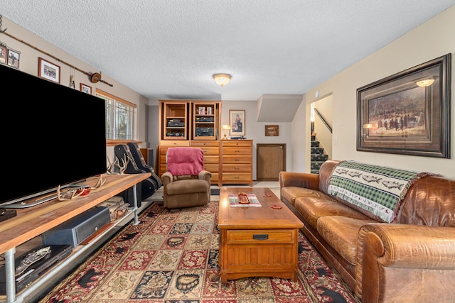 living room featuring stairs and a textured ceiling