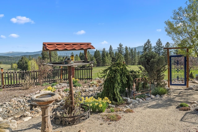 view of yard featuring a mountain view and fence