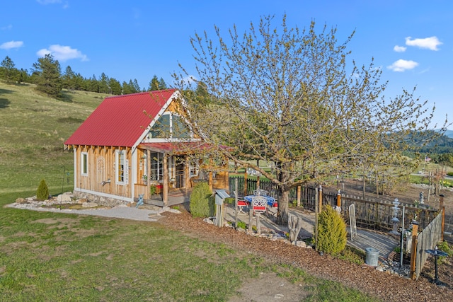 back of house with a lawn, board and batten siding, and metal roof