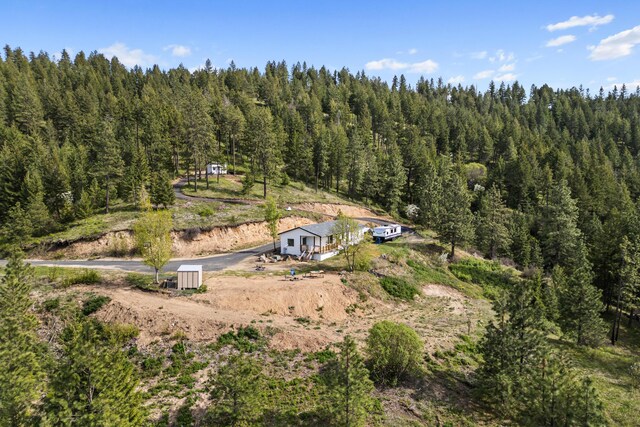 drone / aerial view with a wooded view