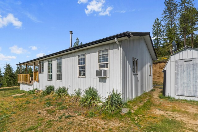 view of side of home with an outdoor structure and a shed