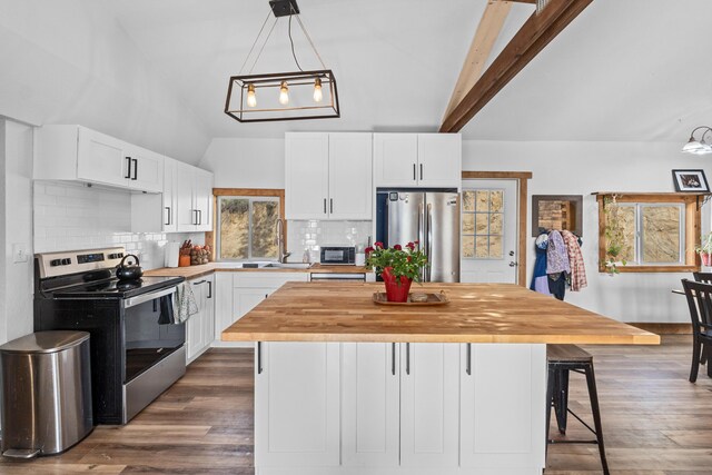 kitchen with decorative backsplash, wood counters, a kitchen island, and stainless steel appliances