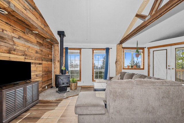 living room featuring wooden walls, a wood stove, and wood finished floors