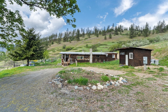 1625 Bear Mountain Way, Kettle Falls, WA 99141 - back of property featuring a storage unit, an outbuilding, and a chimney