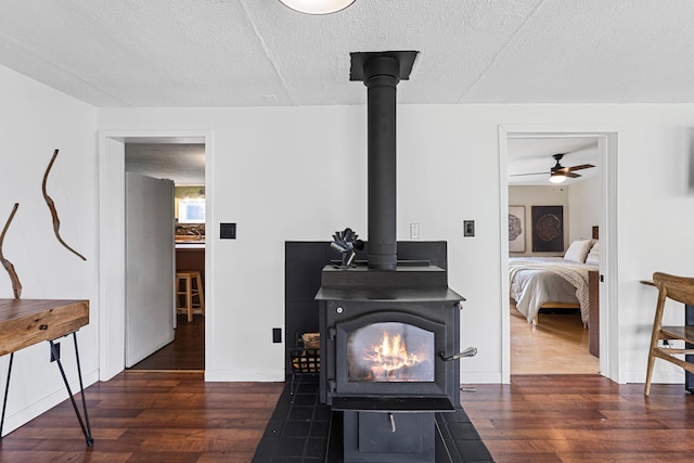 1625 Bear Mountain Way, Kettle Falls, WA 99141 - interior details featuring a wood stove, wood finished floors, baseboards, ceiling fan, and a textured ceiling