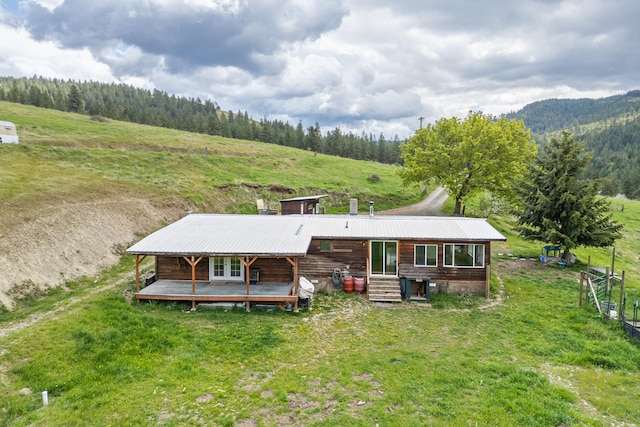 1625 Bear Mountain Way, Kettle Falls, WA 99141 - rear view of property featuring a view of trees, a wooden deck, french doors, and metal roof