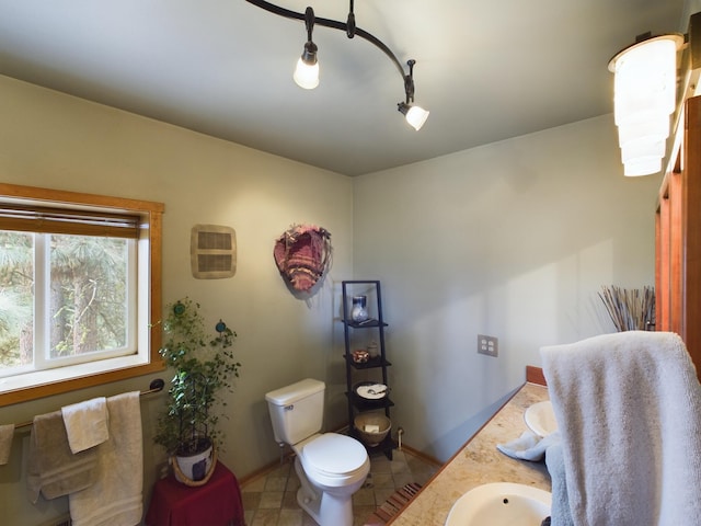 bathroom with toilet, track lighting, and vanity