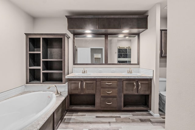 906 Valley Ave, Chewelah, WA 99109 - full bathroom with a garden tub, a sink, wood finished floors, and double vanity
