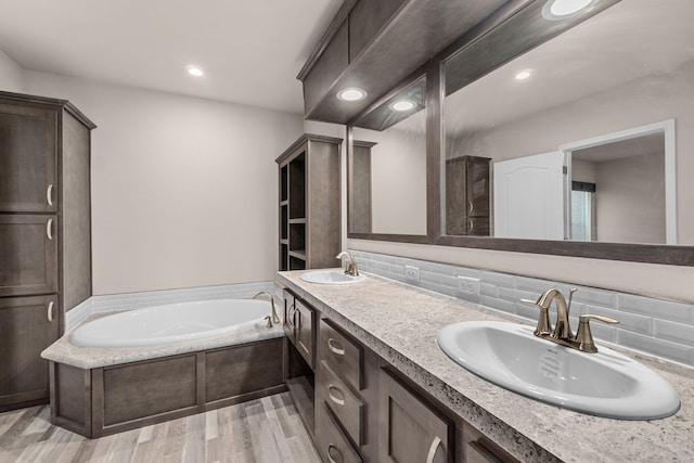 906 Valley Ave, Chewelah, WA 99109 - bathroom with wood finished floors, a sink, a bath, and tasteful backsplash