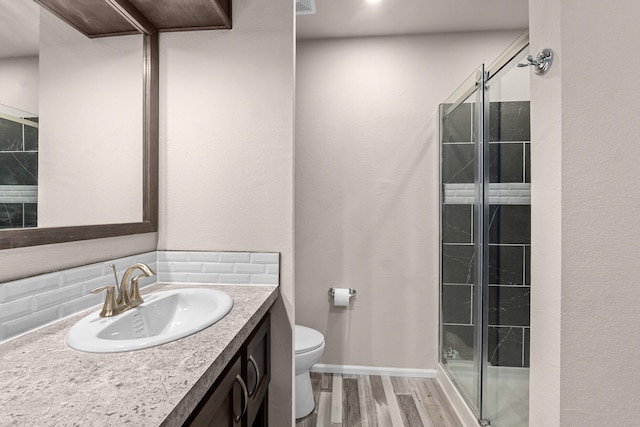 906 Valley Ave, Chewelah, WA 99109 - bathroom with decorative backsplash, a shower stall, wood finished floors, vanity, and toilet