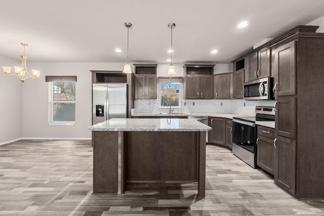 906 Valley Ave, Chewelah, WA 99109 - kitchen with appliances with stainless steel finishes, plenty of natural light, dark brown cabinetry, and light wood-type flooring