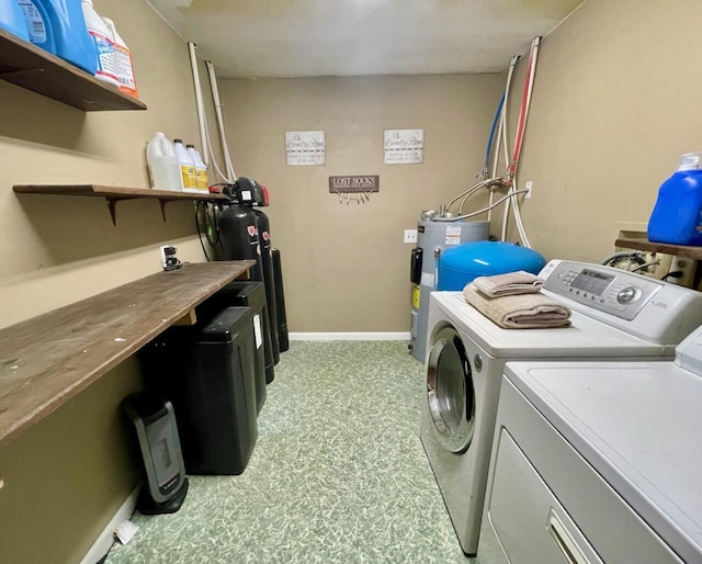 washroom featuring water heater and washing machine and dryer