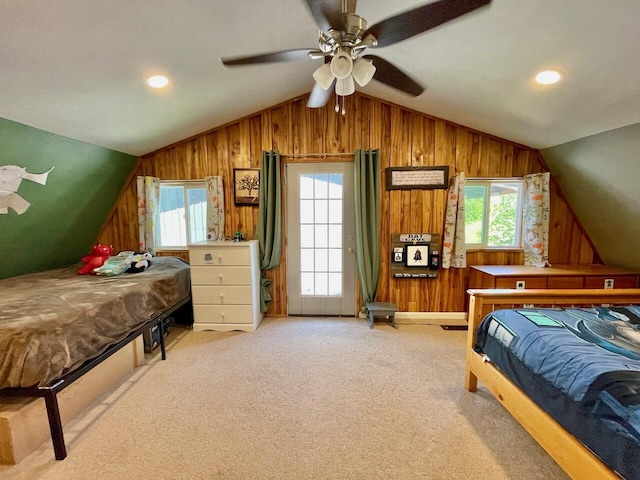 carpeted bedroom with ceiling fan, vaulted ceiling, and multiple windows