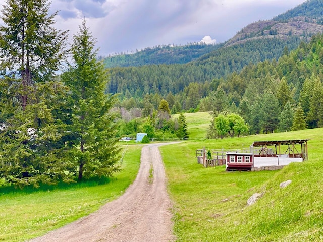 view of property's community with a mountain view, a rural view, and a lawn