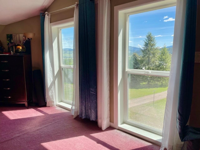 doorway to outside with light colored carpet and lofted ceiling