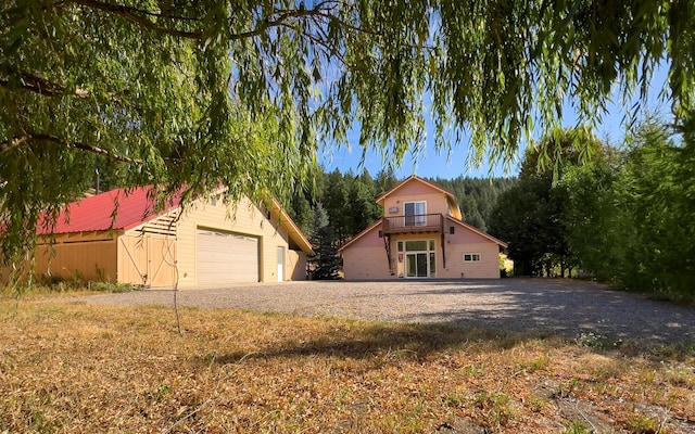 view of front facade featuring an outbuilding, a balcony, and a garage