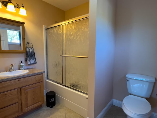 bathroom featuring baseboards, bath / shower combo with glass door, toilet, tile patterned floors, and vanity