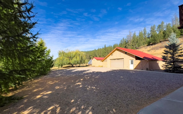 exterior space featuring driveway, a garage, and metal roof