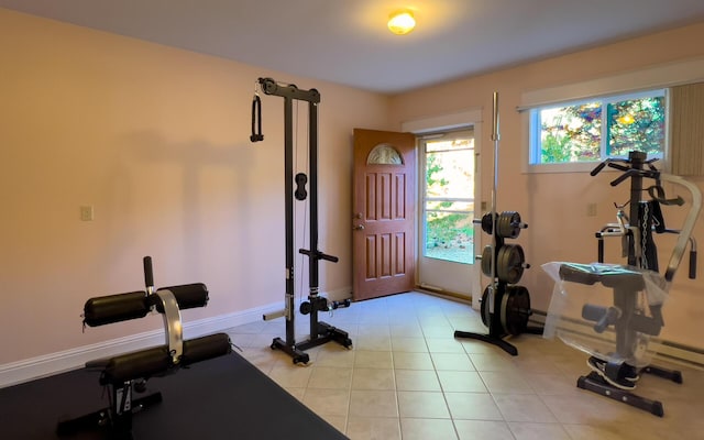 exercise area with light tile patterned floors and baseboards