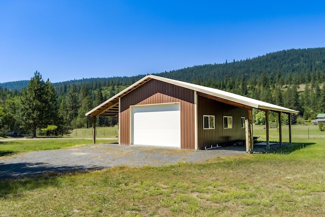 garage featuring a mountain view and a yard