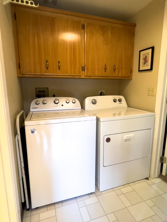 washroom with cabinets and washer and clothes dryer