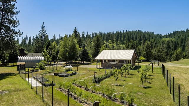 view of community featuring a yard, a rural view, and an outbuilding