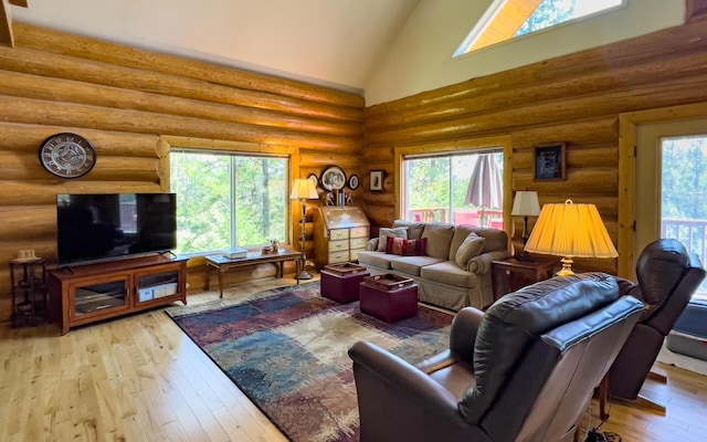 living room with high vaulted ceiling, light hardwood / wood-style flooring, and log walls