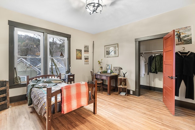 bedroom with light wood-type flooring and a closet