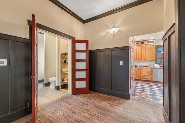 foyer featuring wood-type flooring and crown molding