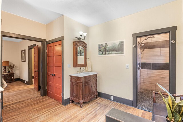 bathroom featuring hardwood / wood-style floors, walk in shower, and vanity