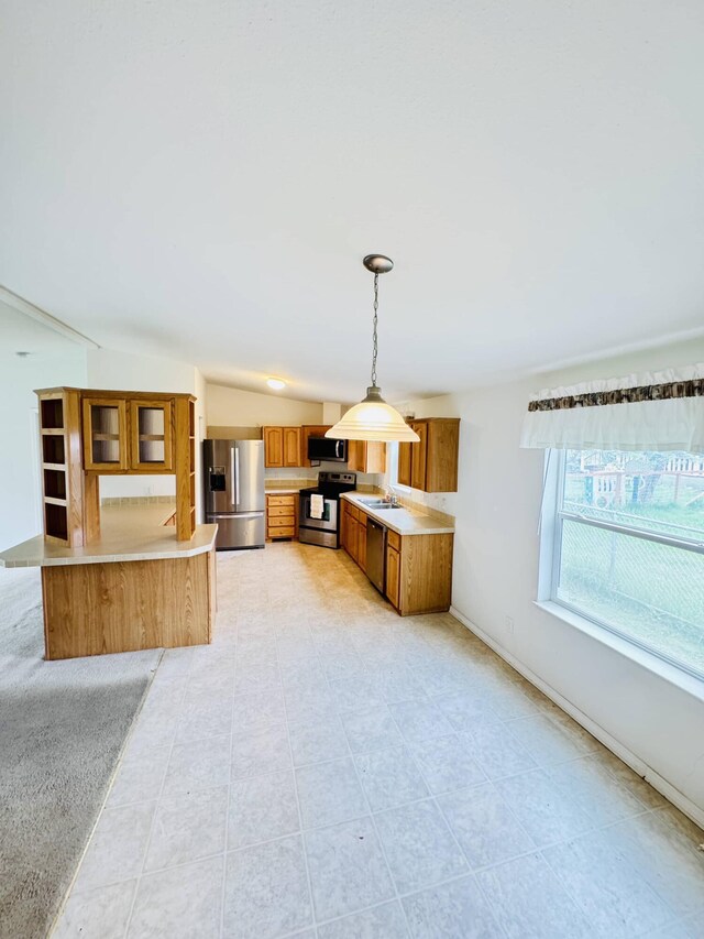 211 8th Ave, Ione, WA 99139 - kitchen with appliances with stainless steel finishes, brown cabinets, light countertops, decorative light fixtures, and glass insert cabinets