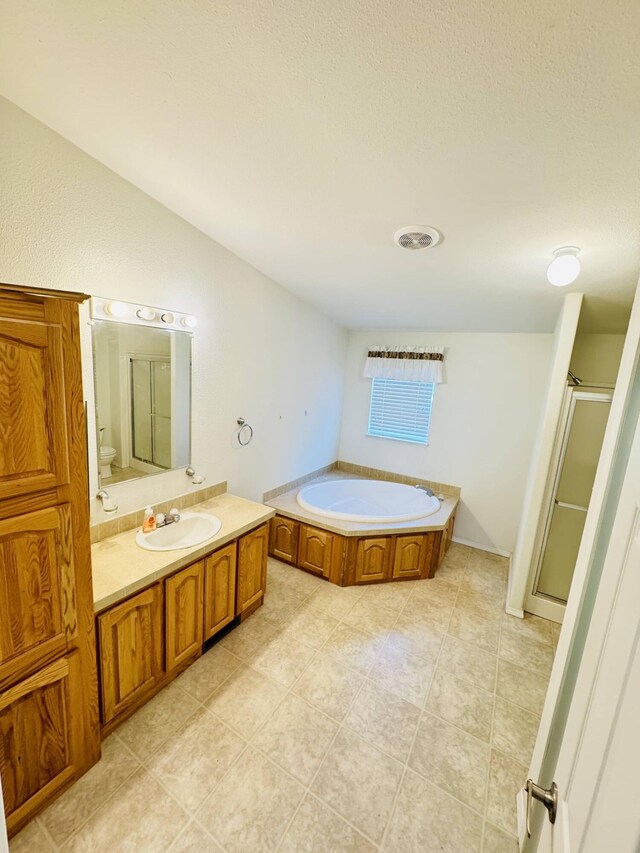 211 8th Ave, Ione, WA 99139 - full bath featuring a bath, toilet, vanity, a shower stall, and tile patterned floors