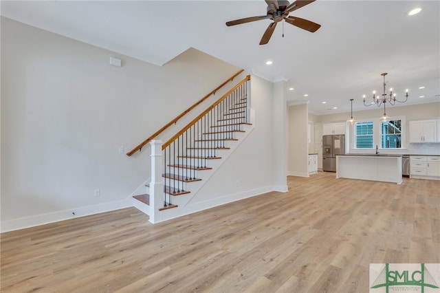 49 Salt Marsh Dr, Midway, GA 31320 - unfurnished living room featuring ceiling fan with notable chandelier, sink, and light hardwood / wood-style floors